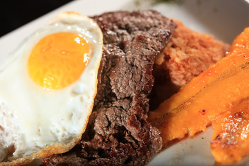 Peruvian traditional steak with fried egg an banana tacu tacu