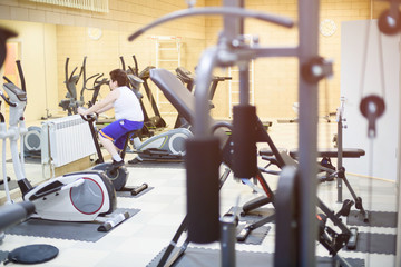 fat little boy on exercise bike training in gym weight loss