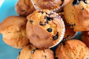 Tasty blueberry muffins on plate, closeup