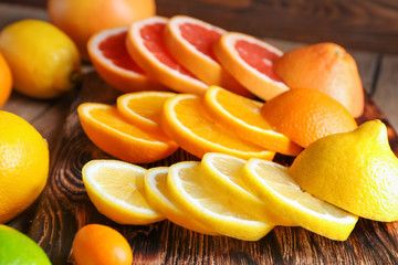 Various cut citrus fruits on wooden board