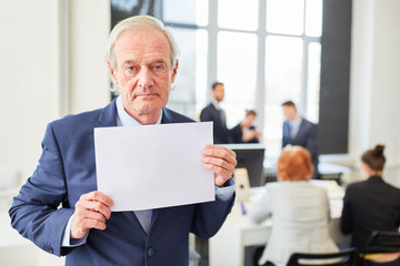Ernster alter Geschäftsmann mit Schild