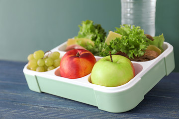 Lunch box with appetizing food on wooden table