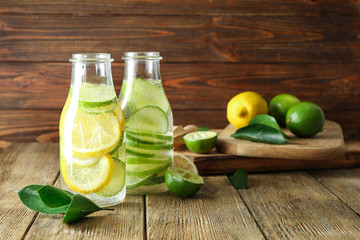 Bottles of fresh lime lemonade on wooden table