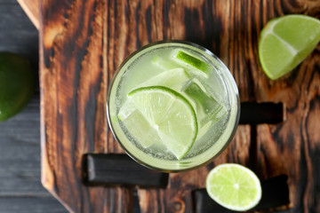 Glass of fresh lime lemonade on wooden board