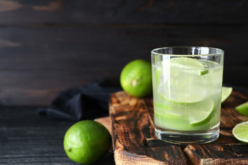 Glass of fresh lime lemonade on wooden board