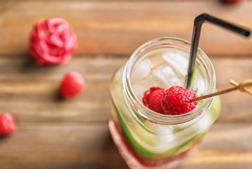 Mason jar of fresh raspberry lemonade on wooden table