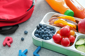 Lunch box with appetizing food on grey table