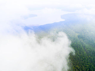 Aerial Drone view clouds over the green forest. Low lying cloud. Aerial view of over tropical rainforest. Above the clouds in the sky. Big clouds. Atmosphere and stratosphere. Top view from drone