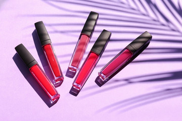 Different liquid lipsticks on color background