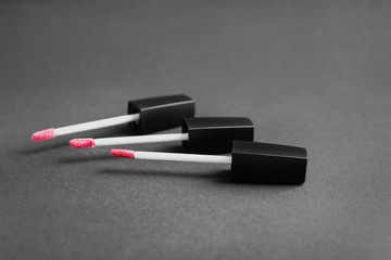 Brushes with color lipstick on grey background