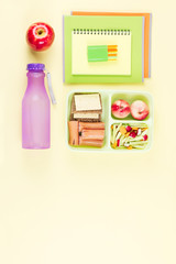 School concept flat lay. Kid backpack, lunchbox, water bottle, notebook, markers on wooden desktop