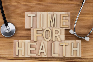 time for health -  text in vintage letters on wooden blocks with stethoscope . Medicine concept