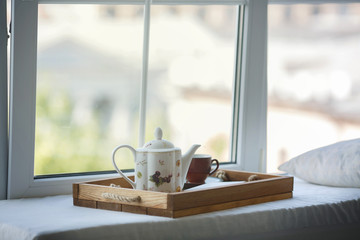 teapot and a cup on the window. Outside the window is sunny autumn. Still life.