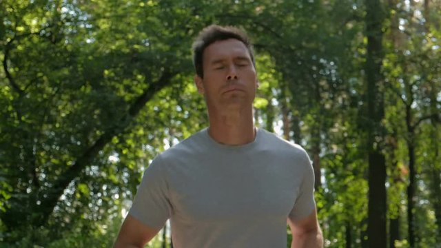 Portrait of an Athletic caucasian sportsmen running through the woods.