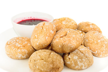 Sweet cakes on white plate and saucer with berry jam on isolated white background