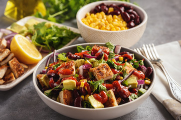 Chicken salad with avocado, corn and bean.