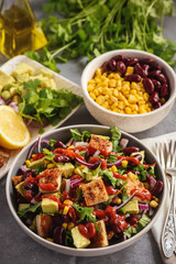 Chicken salad with avocado, corn and bean.