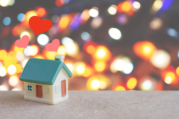 Miniature house with heart sign and blur light bokeh ,love family concept.