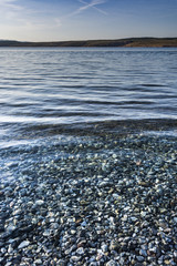 Stone beach and clear blue sea in Croatia. Many white stones under the sea level.