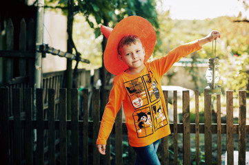 Boy on Halloween day with a lantern in his hands .