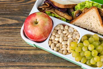 Lunch box with appetizing food on wooden table