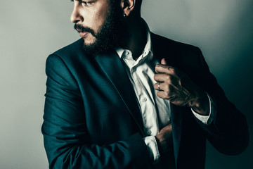 Bearded man reaching inside his pockets 