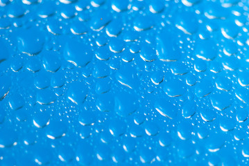 Drops Of Rain On Blue Glass Background. Soft focus macro shot with shallow depth of field
