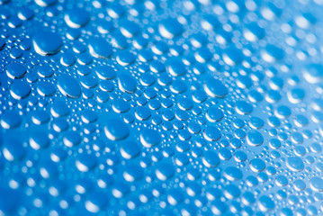 Drops Of Rain On Blue Glass Background. Soft focus macro shot with shallow depth of field