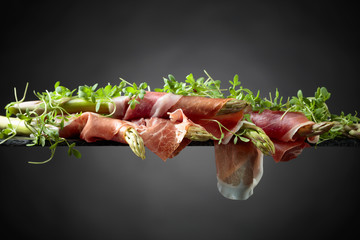 Asparagus wrapped in prosciutto .