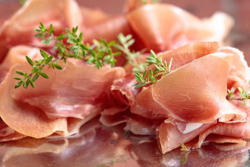 Italian prosciutto crudo or jamon with thyme .