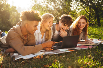 Group of happy multhiethnic students doing homework