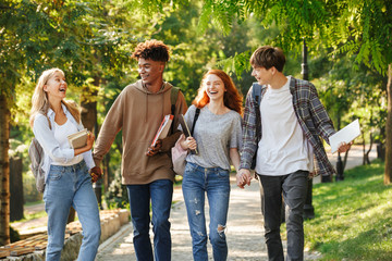 Group of laughing student walking at the campus