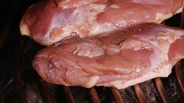 1080p dolly shot of two delicious duck breasts cooking on a barbecue set