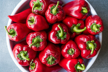 Whole Red Peppers in White Bowl. Close Up View.