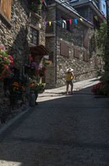 Fototapeta na wymiar woman walking on foot a mountain village in spring in the Pyrenees