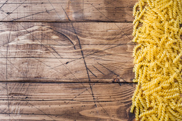 Wooden empty background and the strip of dry pasta. Copy space