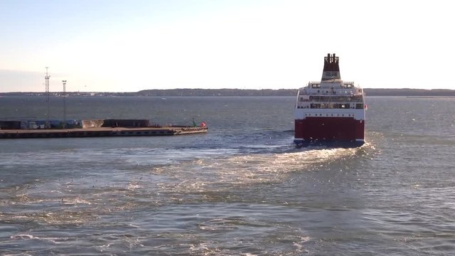 The farry ship leaves the port, leaving a trail on the water