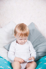 Fototapeta premium Happy child baby toddler sitting smiling kissing mobile cellphone on a white background