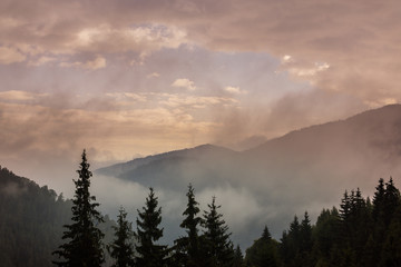 Summer mountain scenery with mist clouds, at sunset