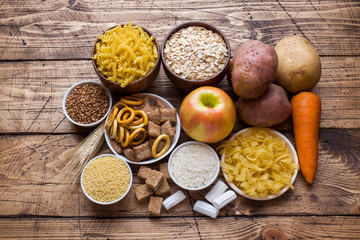 Foods high in carbohydrate on rustic wooden background.