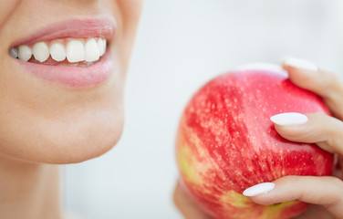 Closeup Portrait Of Young Beautiful Female Holding Apple. Dental Health Care Concept. Healthy White Teeth. Fresh Perfect Smile.