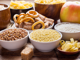 Foods high in carbohydrate on rustic wooden background.