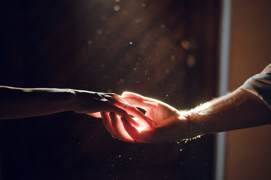 Wedding Couple Hands. Man And Woman Holding Hands In The Dark On The Sun Ray. Close Up