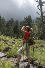 Woman hiking with a straw hat and backpack through the Spanish Pyrenees