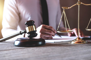 Male lawyer or judge working with Law books, gavel and balance, report the case on table in office,...