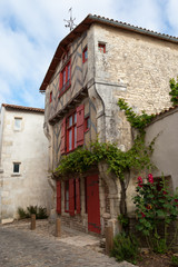 Fototapeta na wymiar France, Isle of Re, old stone house with red shutters.