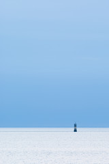 Fototapeta na wymiar Small and Lonely Lighthouse on the horizon.