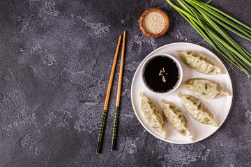Asian dumplings, soy sauce, chopsticks, top view