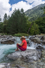 Woman hiking with a straw hat and backpack through the Spanish Pyrenees