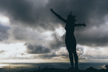 the girl stands on the edge of a high mountain to the wind blew her hair and body